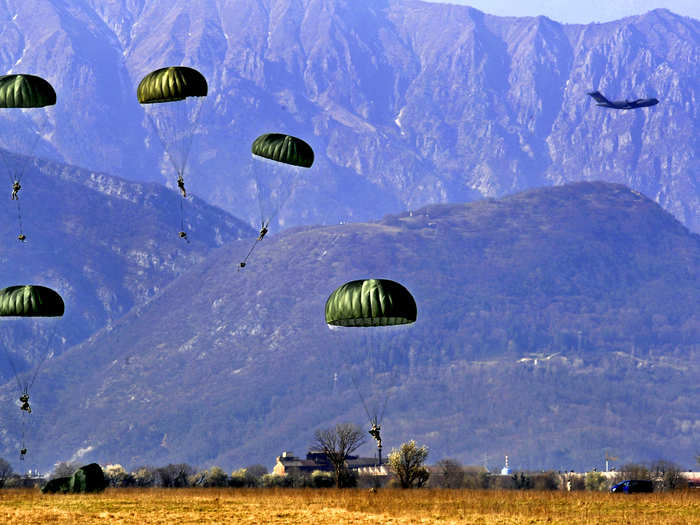 Members from the US Army 173rd Airborne Brigade Combat Team conducts combat jump operations from a C-17 Globemaster III during a joint coalition training exercise in Italy.