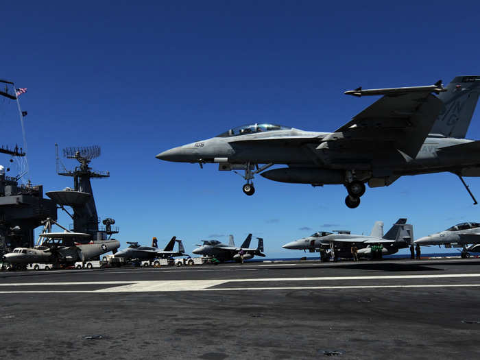 An F/A-18F Super Hornet from the Black Aces of Strike Fighter Squadron 41 lands aboard the Nimitz-class aircraft carrier USS John C. Stennis.