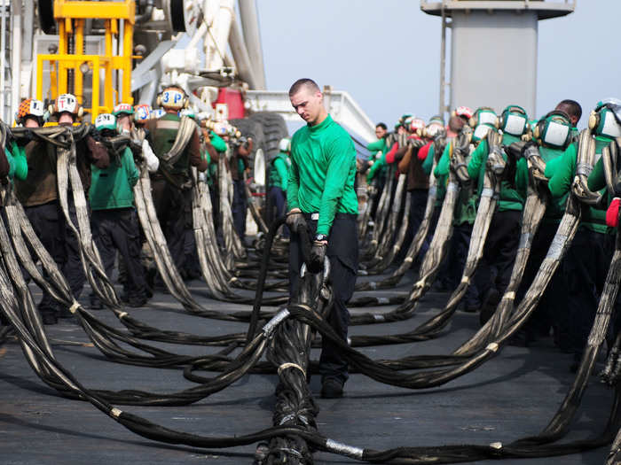 Sailors stow an aircraft barricade after flight deck drills aboard the aircraft carrier USS Ronald Reagan.