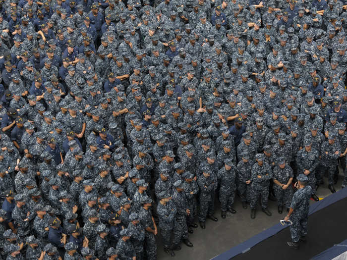 Ship executive officer addresses Sailors on the flight deck during an all-hands call on the aircraft carrier USS Carl Vinson.