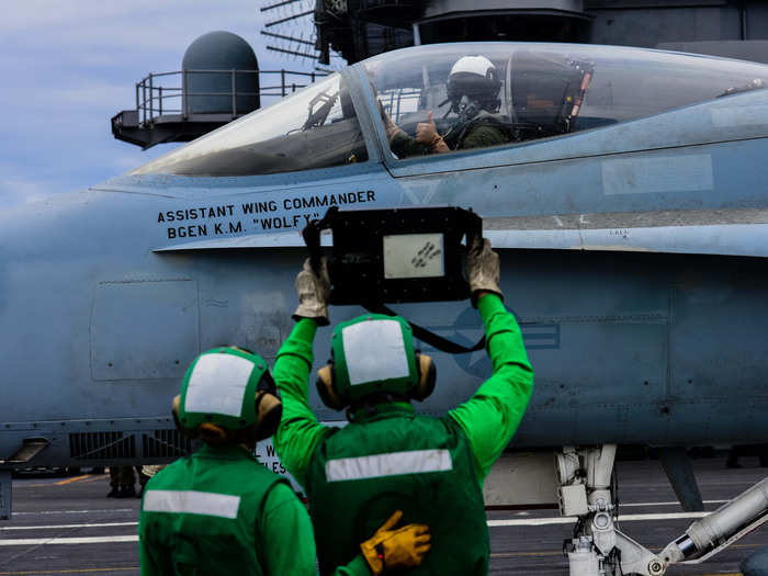 A pilot confirms the weight of his jet prior to launch on the flight deck of the Nimitz-class aircraft carrier USS John C. Stennis.