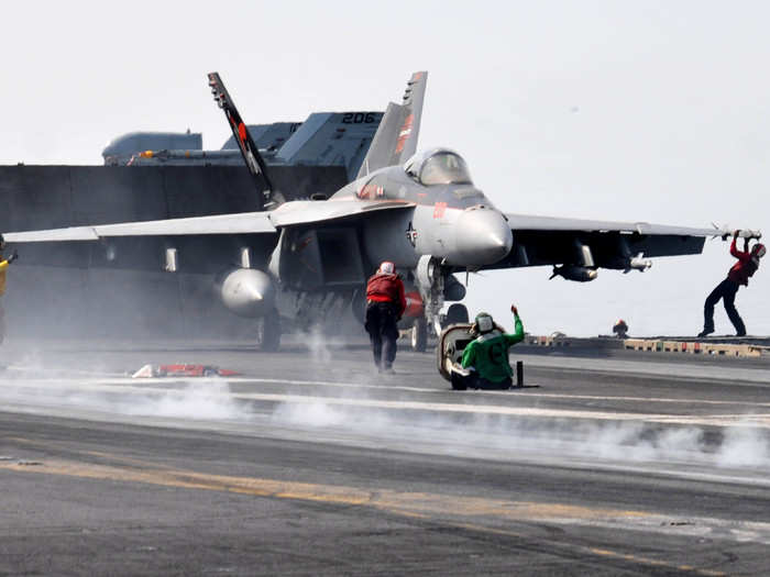 Sailors prepare an F/A-18E Super Hornet on the USS Ronald Reagan.