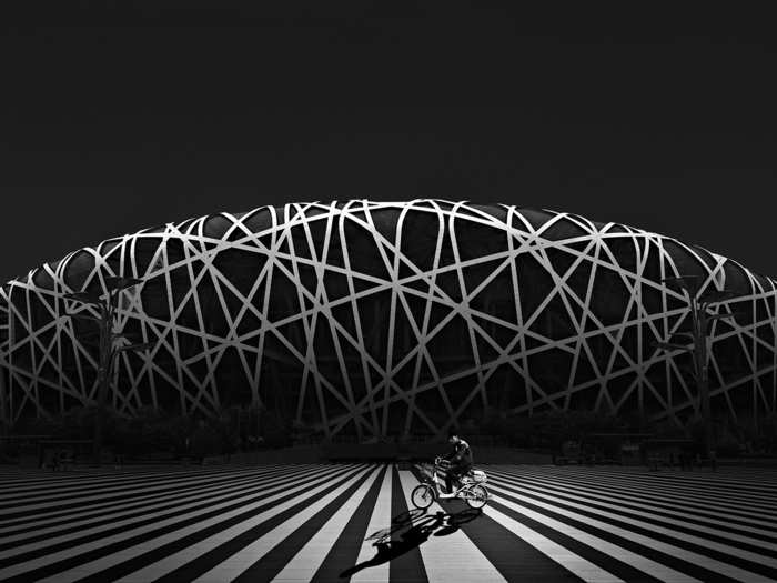 A man rides a bike in front of Bird