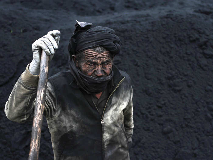 A laborer takes a break at a coal-dump site outside Mazar-i-Sharif, November 6, 2014.