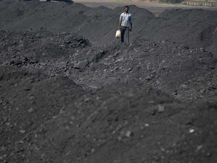 All in all, global demand for coal has stalled for the first time since the 1990s, according to the International Energy Agency, which expects coal’s share of global power generation to fall from 41% now to 37% by 2020, even has use rises in India and Southeast Asia. Here, a worker carries a container filled with drinking water at a railway coal yard on the outskirts of the western Indian city of Ahmedabad.