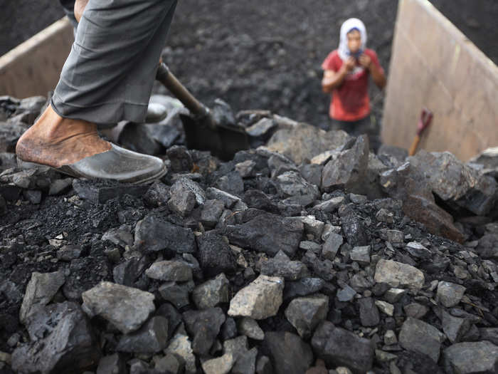 Workers unload coal from a truck into a stock field in Cigading harbour in Cilegon, Banten province, October 14, 2010. Indonesia, the world