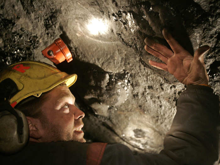 Steve Torgersen, a Norwegian mining expert, shows the size of a fossil footprint of a hippopotamus-like creature, a pantodont, on the roof of a coal mine on the Norwegian Arctic island of Spitsbergen, April 24, 2007.