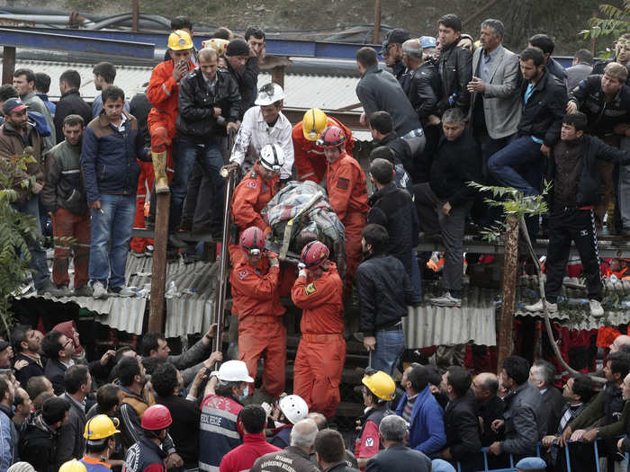 Rescuers carry a miner who sustained injuries after a mine explosion to an ambulance in Soma, a district in Turkey