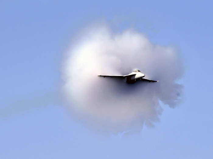 An F/A-18 Super Hornet assigned to the Kestrels of Strike Fighter Squadron 137 breaks the sound barrier during an air power demonstration above the Nimitz-class aircraft carrier USS Abraham Lincoln.