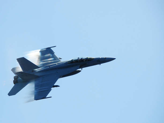 An F/A-18F Super Hornet assigned to the Bounty Hunters of Strike Fighter Squadron 2 breaks the sound barrier during a fly-by of USS Ronald Reagan.