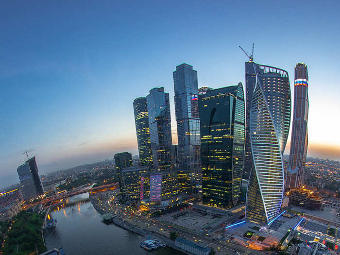 In this photo, Nikolau can be seen laying at the edge of a roof from a height of 341 feet. In the background is a stunning shot of Moscow.