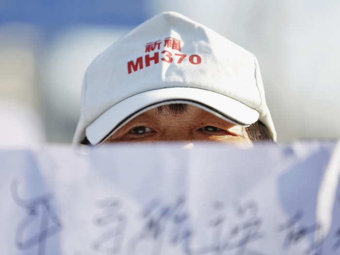 A family member of a passenger onboard Malaysia Airlines flight MH370, which went missing in 2014, holds a banner during a gathering in front of the Malaysian Embassy on the second anniversary of the disappearance of MH370, in Beijing, China, March 8, 2016.