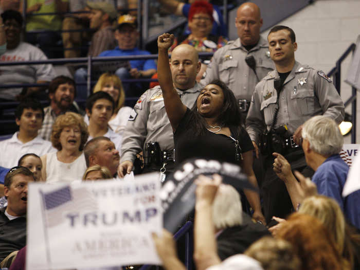 A demonstrator raises her fist in protest against US Republican presidential candidate Donald Trump as police officers approach to remove her from a campaign rally in Fayetteville, North Carolina, on March 9.