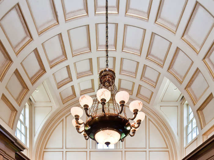 High ceiling panels adorned in solid gold line the home’s library.