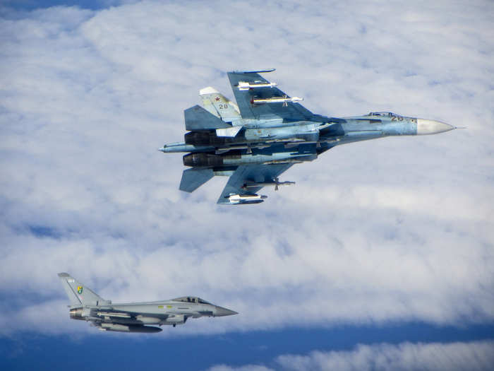 A Russian SU-27 Flanker aircraft banks away with a RAF Typhoon in the background. RAF Typhoons were scrambled on Tuesday 17 June 2014 to intercept multiple Russian aircraft as part of NATO’s ongoing mission to police Baltic airspace.