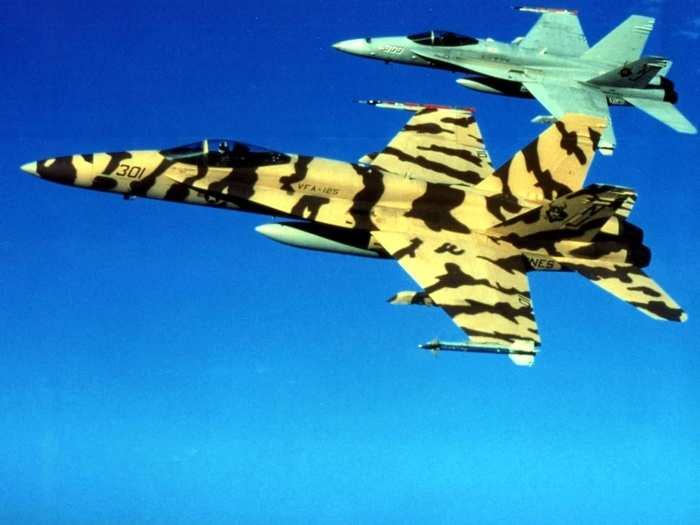 A US Navy F/A-18C Hornets of the Strike Fighter Squadron VFA-125 "Rough Raiders" flies in formation flight out of Naval Air Station Lemoore, California (USA) with an unusual tiger stripe camouflage.