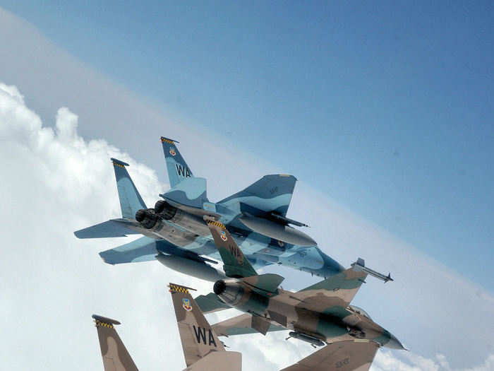 A flight of Aggressor F-15 Eagles and F-16 Fighting Falcons with various camouflage schemes fly in formation over the Nevada Test and Training Ranges on June 5, 2008.