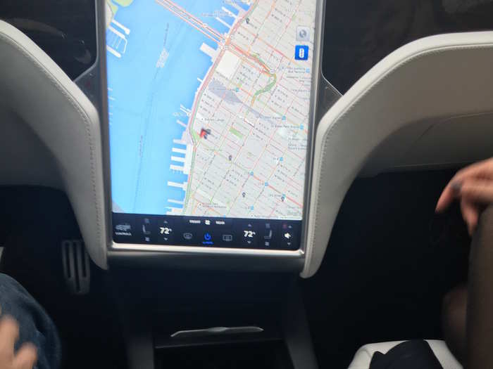 Teslas are defined, inside, by this large central touchscreen, which controls almost all vehicle functions. Also, note the curved, brushed-metal cupholders: a new design!