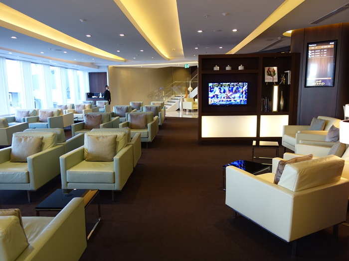 The lounging area was beautifully furnished with classy white and brown leather chairs.