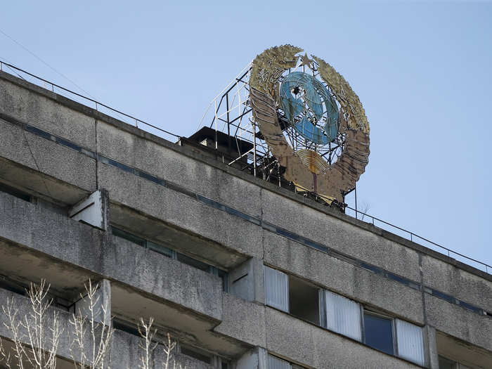 The coat of arms of the former Soviet Union sits on top of an abandoned apartment building in Pripyat.