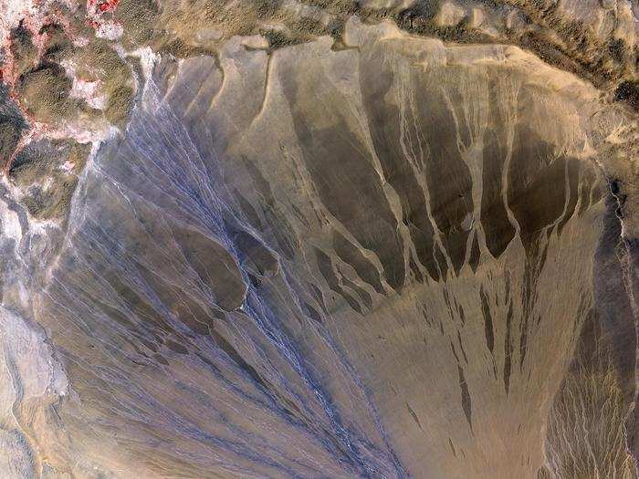 This triangular deposit of gravel, sand, and salt in China is called an alluvial fan.