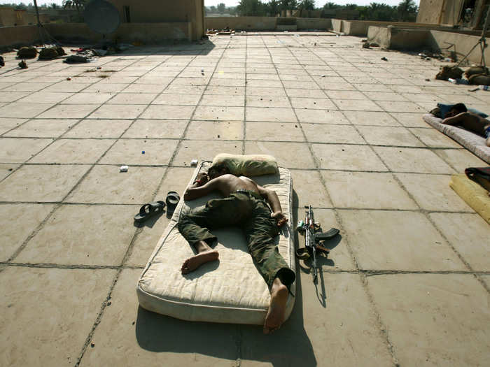 An Iraqi soldier sleeps next to his Kalashnikov rifle on the roof of a base in Baquba June 29, 2007.