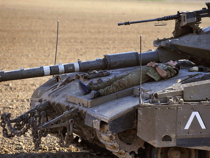 An Israeli soldier sleeps atop a tank near Kibbutz Kissufim, just outside the central Gaza Strip November 5, 2008.