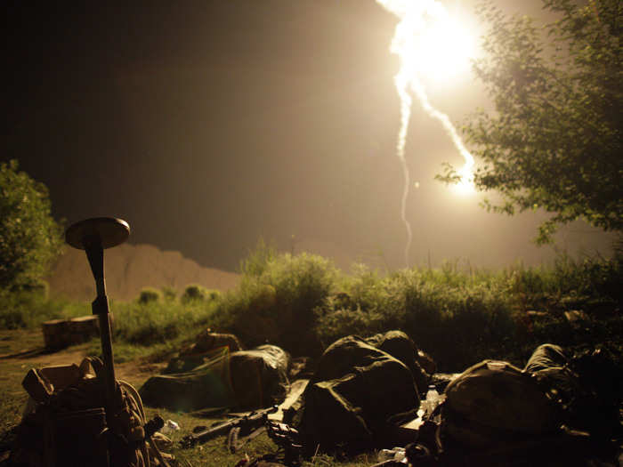 Canadian soldiers sleep as a flare burns over them during a special operation at Sanjaray in Kandahar Province, May 18, 2009.