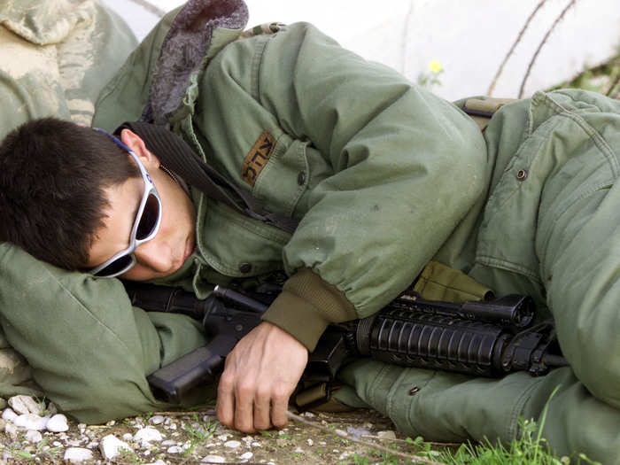 An Israeli soldiers sleeps after returning from the Gaza Strip to the Israeli controlled Erez crossing February 13, 2002.