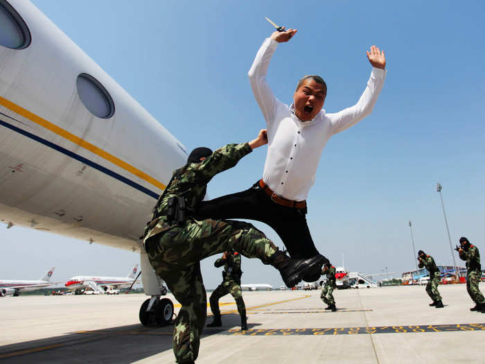 Sometimes sessions involve acting out real life scenarios. Below, a paramilitary policeman knocks down a man role-playing as a plane hijacker during an anti-terrorism drill.