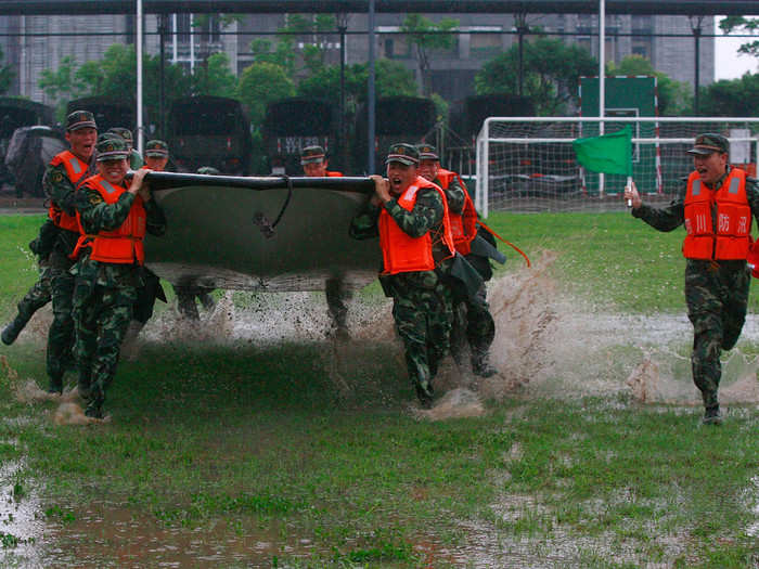 They carry boats across flooded grasslands during drills.