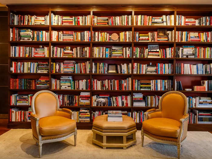 The bookshelf is a centerpiece of the apartment, stacked with tomes. Huffington has published 14 books.