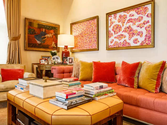 Plush velvet pillows and pink-hued artworks keep things cozy in this corner of the open-plan living room.