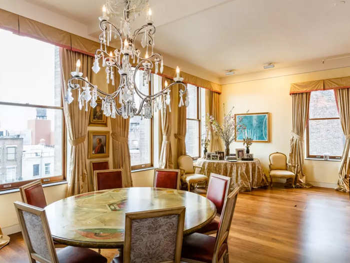 The dining table is lit by a hanging crystal chandelier.