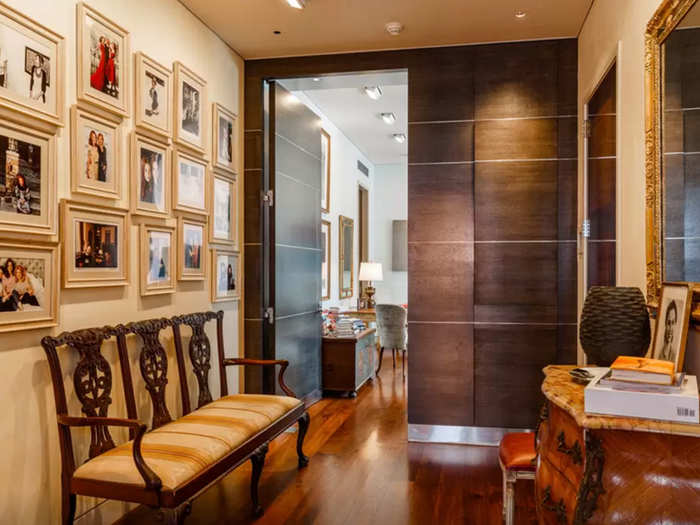 The hallway space is decorated with family photos, many showing Huffington and her two daughters.