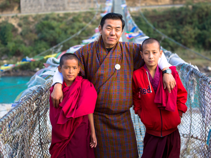 Guides assist tourists with planning and executing their trip. Pictured here is tour guide Karma Lotey, dressed in the traditional Bhutanese gho. Both men and women wear traditional uniforms during business hours. Men wear the gho, while women wear the kira, a long dress.