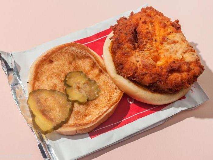 The sandwich consists simply of a fried-chicken-breast fillet and tart pickles embraced by a toasted, buttered bun.