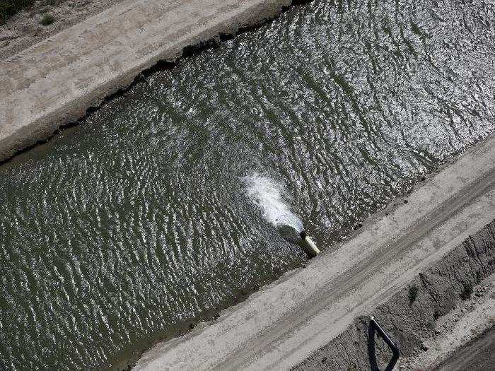 Water pours into a dried-out canal in Los Banos.