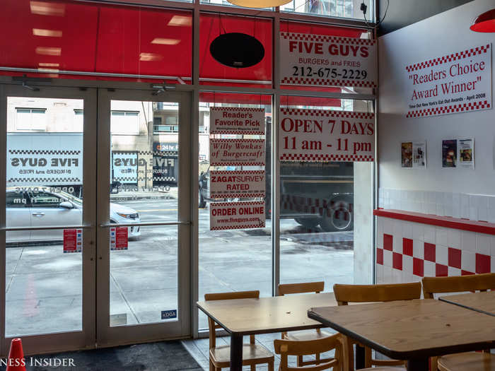 ... replaced by simple utilitarian tables and chairs surrounded by white tile walls with the signature red-checker design. Five Guys feel like clean, uniform, hole-in-the-wall delis — in a good way. There