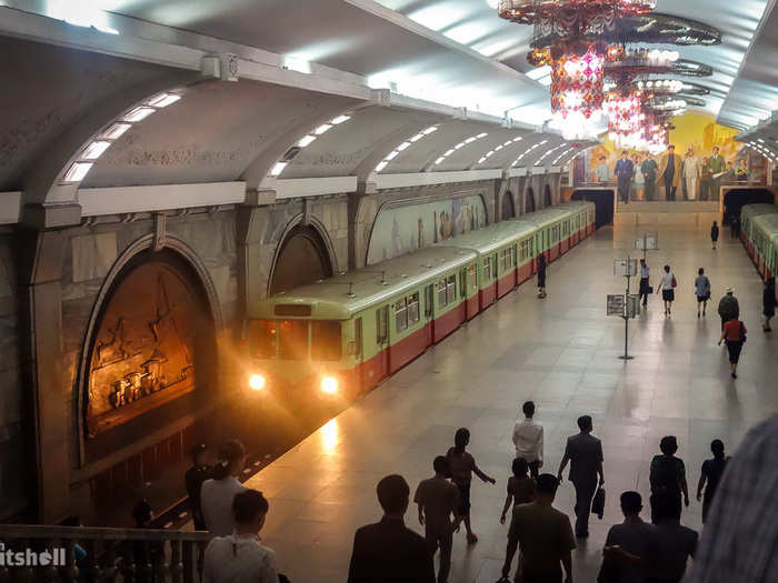 This is Puhung Station, the metro terminal of the Chollima line. Before 2010, Puhung was one of only two metro stations foreign visitors were allowed into, even with mandatory guides. The other, Yonggwang Station, is just one stop ahead. Both stations are regarded as the most lavish and were the final two to be completed, likely the reason they were chosen as showcase stations for tourism itineraries. The mural to the back is entitled ‘The Great Leader Kim Il-Sung Among Workers’.