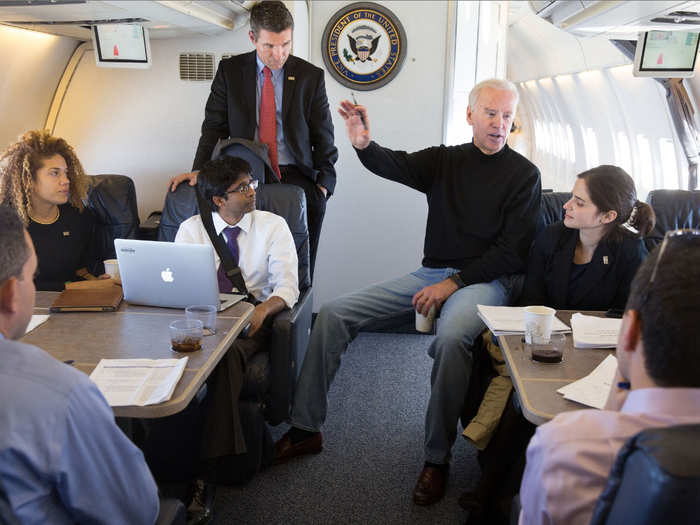 Biden talks with his staffer aboard Air Force Two on January 24, 2015.