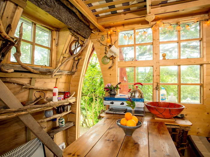 The kitchen is stocked with pots, pans, crockery, a kettle, and a small cold box for storing cool food, as well as a stove and grill. Thankfully, the treehouse is fully insulated with double-glazed windows and heating so you won