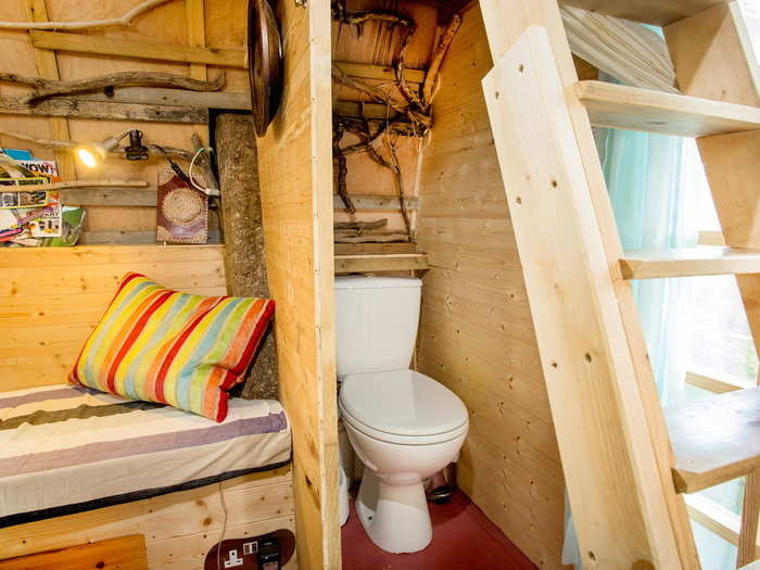 A small bathroom with a composting toilet is tucked away behind a curtain. Guests can also use a wash basin, while a separate shared shower is located outside of the treehouse.