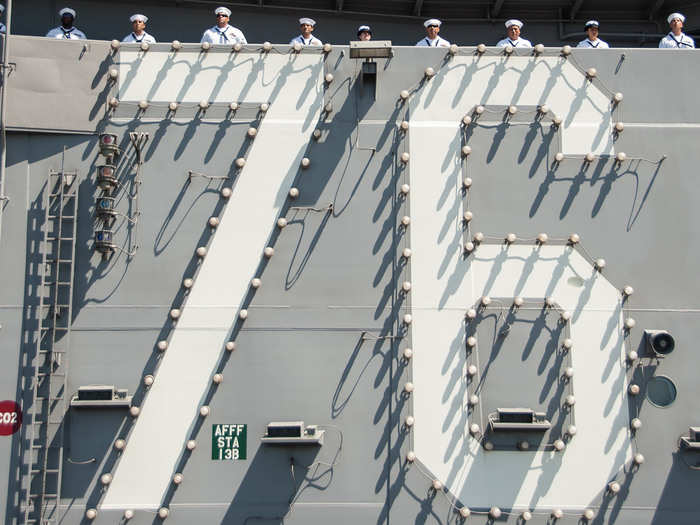 Sailors man the rails of the Nimitz-class aircraft carrier USS Ronald Reagan (CVN 76) while departing Naval Base Coronado (NBC).