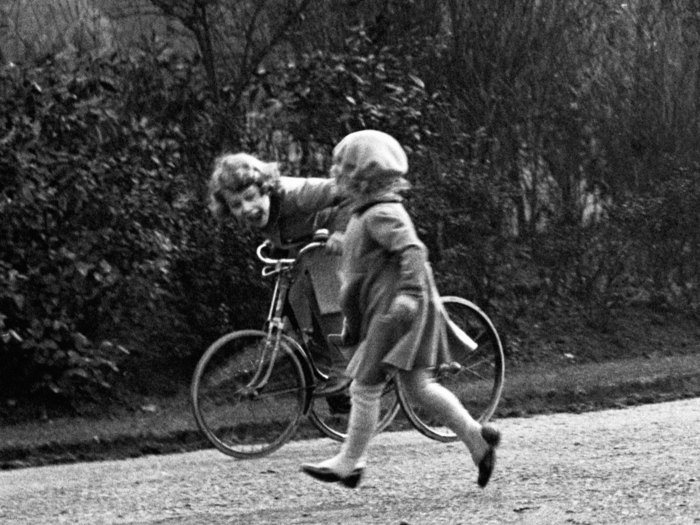 1933: This adorable photo shows a 6-year-old Elizabeth playing on a tricycle in the park.