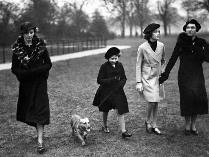 1936: In this picture, a young Elizabeth takes her pet dog for a walk in Hyde Park, London. She spent much of her childhood in 145 Piccadilly, a townhouse located next to The Ritz and bordering the city