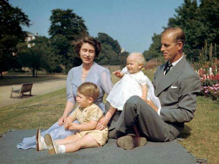 1951: This summer picture shows the soon-to-be queen, husband Prince Philip, and their children Charles and Anne on the lawn at Clarence House, London.