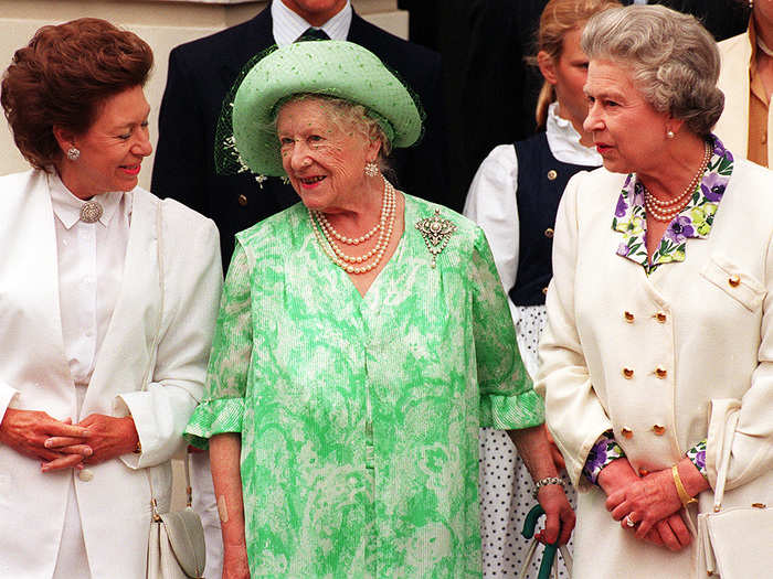 1993: The Queen Mother, stands between her two daughters, Queen Elizabeth II and Princess Margaret while celebrating her 93rd birthday at Clarence House in London. 1993 was also the year Buckingham Palace was opened to the public for the first time.