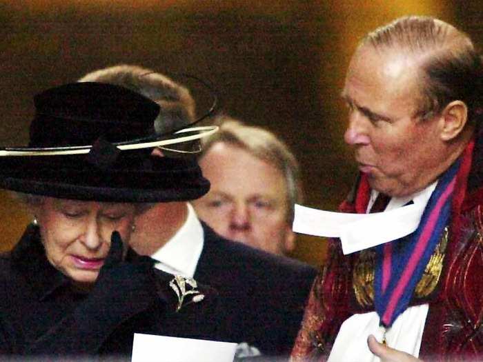 2001: The following year, the world remembered those who lost their lives in the attacks of 9/11. In this picture, a distraught Queen Elizabeth II wipes a tear from her face as she