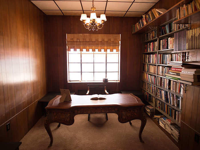 A total of 25 rooms are scattered throughout the mansion, including this wood-paneled library.